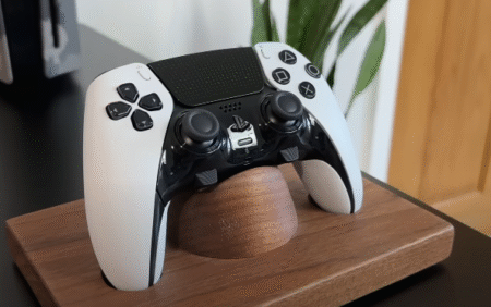 A white Sony DualSense Edge Controller rests on a wooden stand, showcasing its sleek design and modern features.